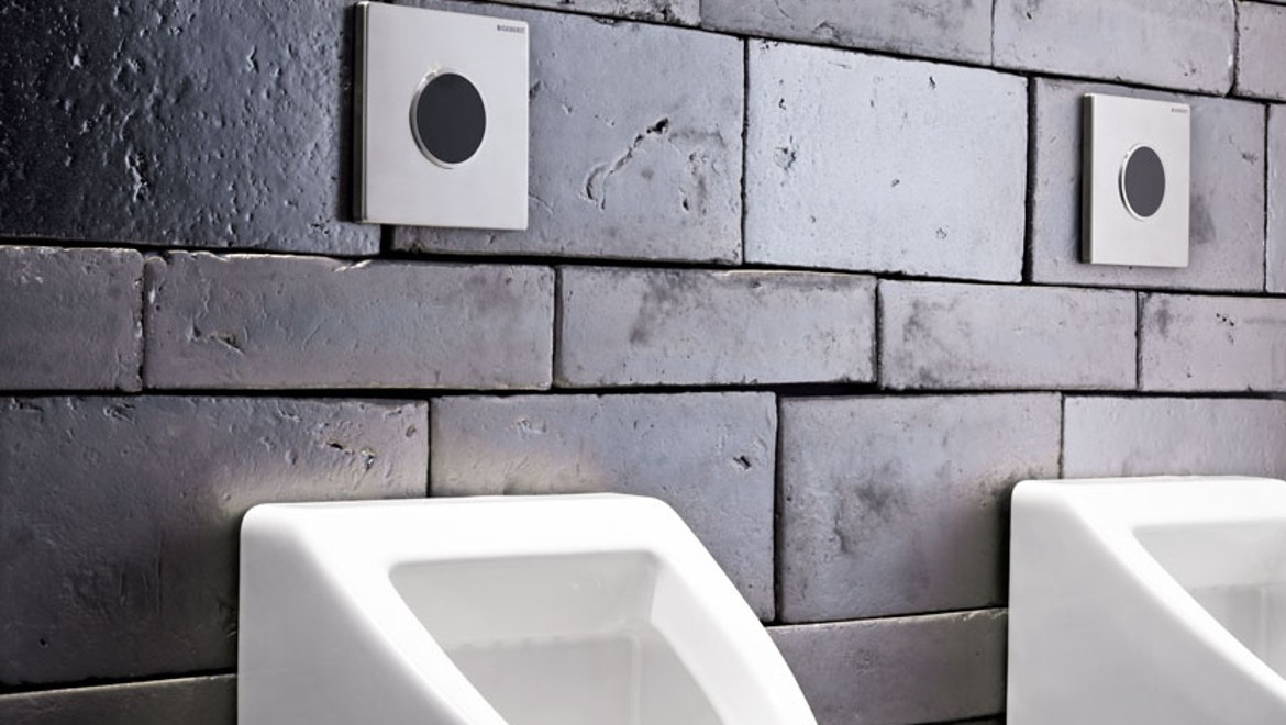 Type 10 urinal flush plates on stone wall