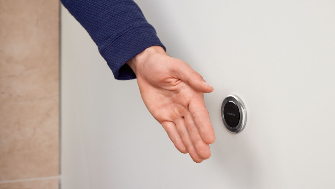 Geberit Type 10 touchless remote flush being activated by hand