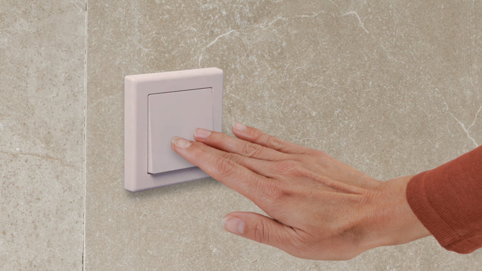 Hand operating a Geberit electrical remote push-button flush Hand operating a Geberit electrical remote push-button flush