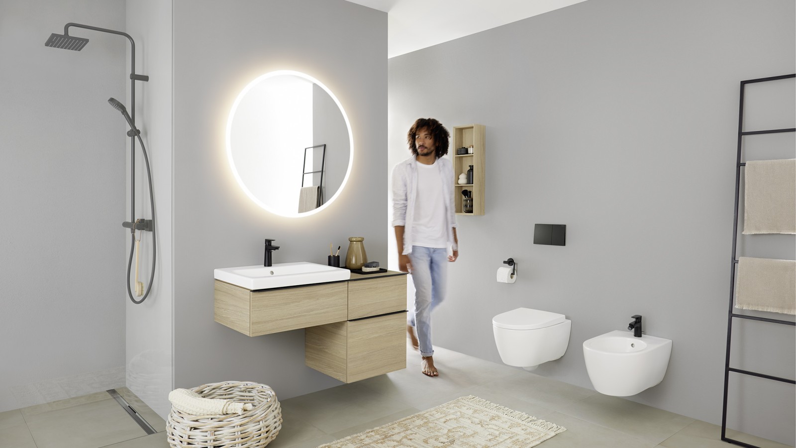 Man walks into the bathroom with washbasin, toilet, bidet, and bathroom furniture