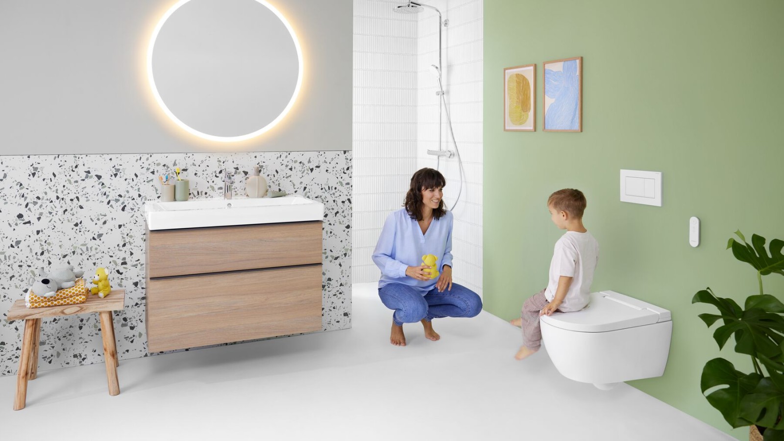 Woman and child in a colorful bathroom with lighted mirror wall-hung toilet
