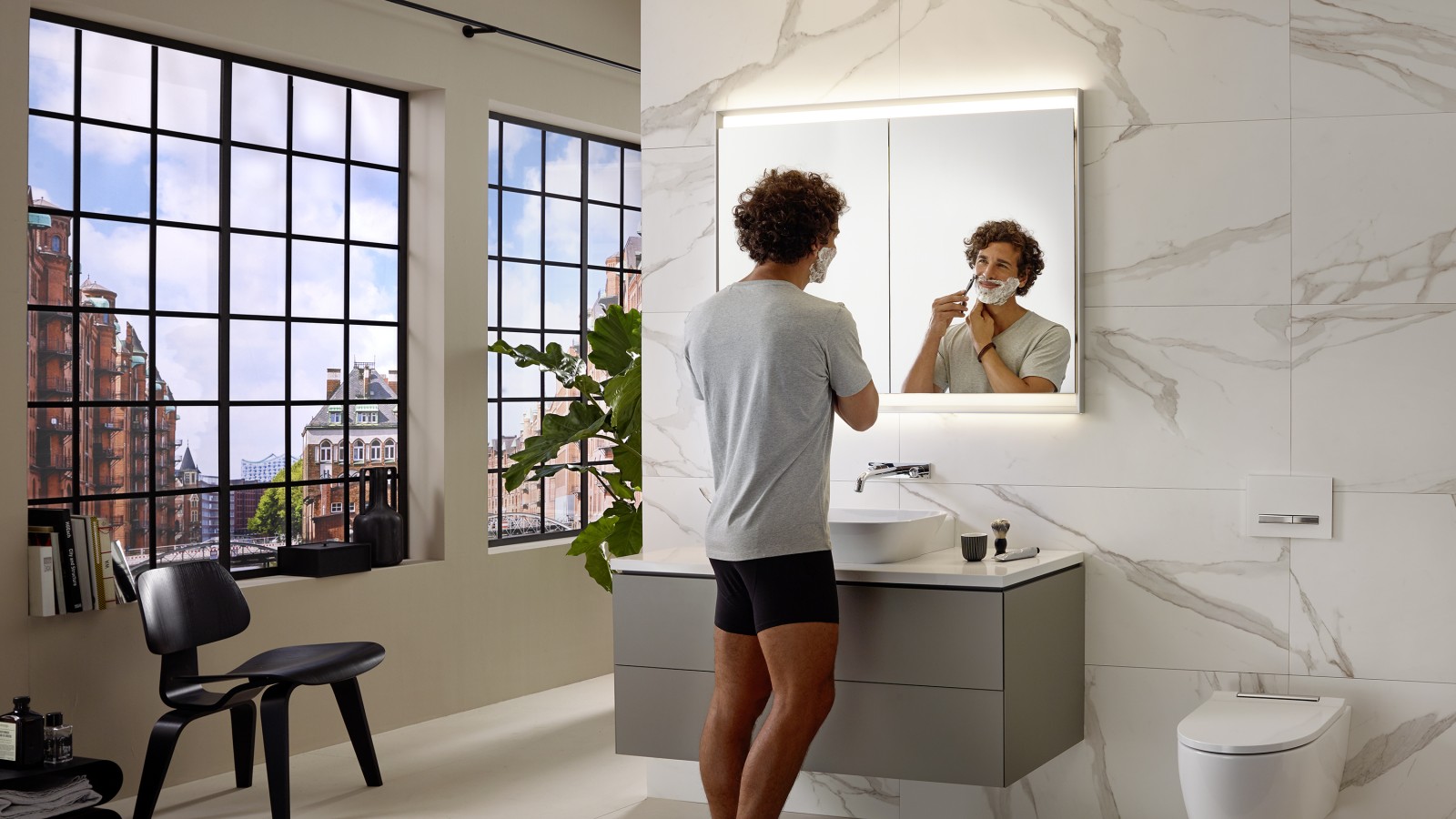 Man shaving at washbasin with Geberit ONE furniture and mirror cabinet Man shaving at washbasin with Geberit ONE furniture and mirror cabinet