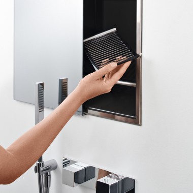 Woman’s hand positioning a shelf in the niche storage box in the shower (© Geberit)
