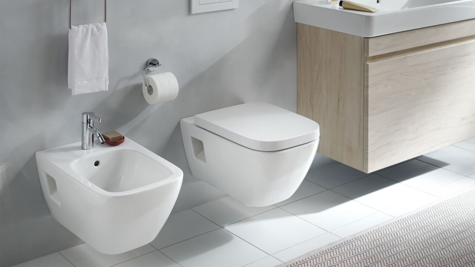 Geberit Sigma in-wall bidet and toilet systems installed in a light, modern bathroom Geberit Sigma in-wall bidet and toilet systems installed in a light, modern bathroom